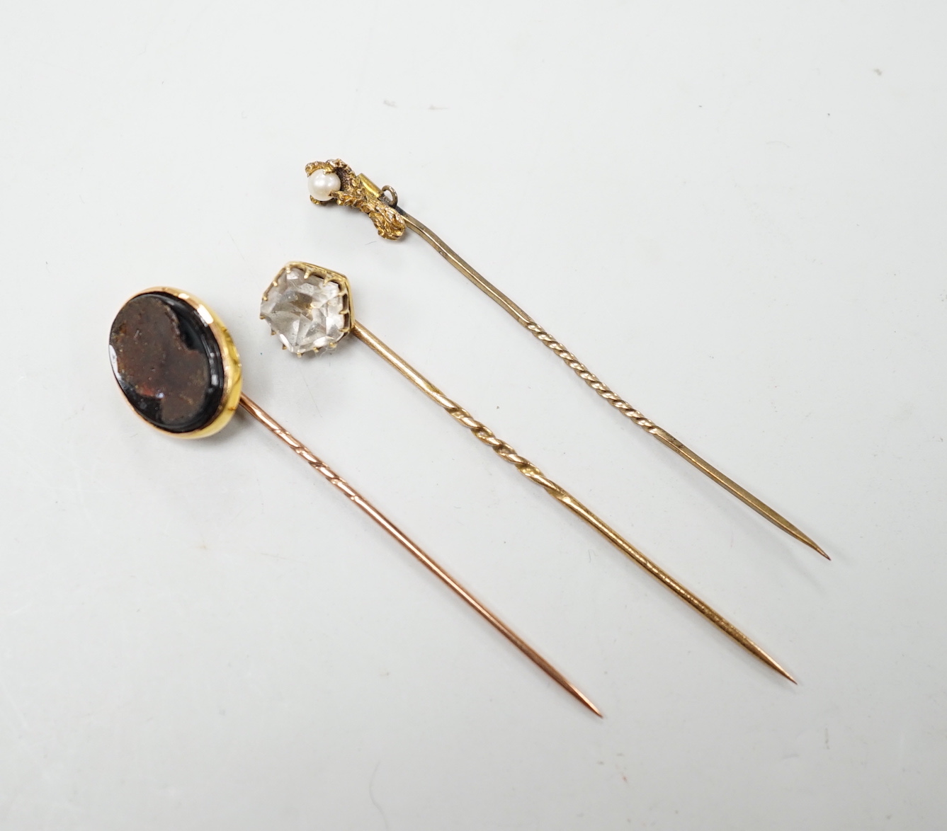 Three assorted stick pins including seed pearl and claw.